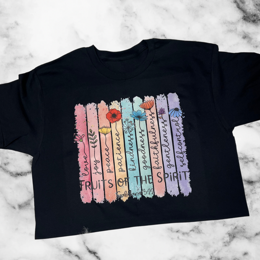 Black t-shirt with colorful 'Fruits of the Spirit' design on a marble background