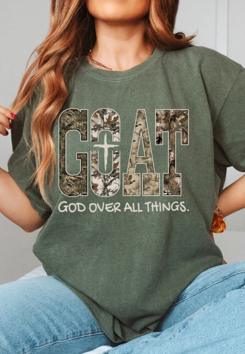 Person wearing a green t-shirt with 'GOAT GOD OVER ALL THINGS' text