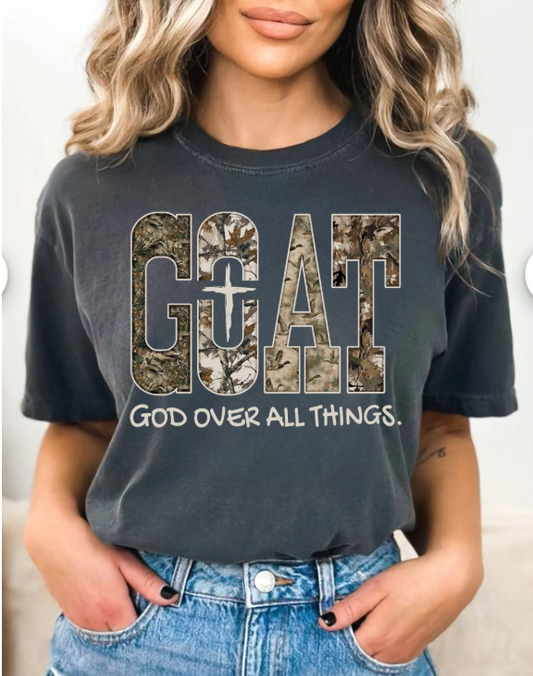 Person wearing a pepper t-shirt with 'GOAT God Over All Things' text and camouflage design.