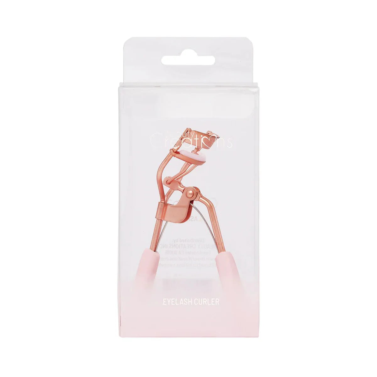 Rose gold eyelash curler in packaging on a white background
