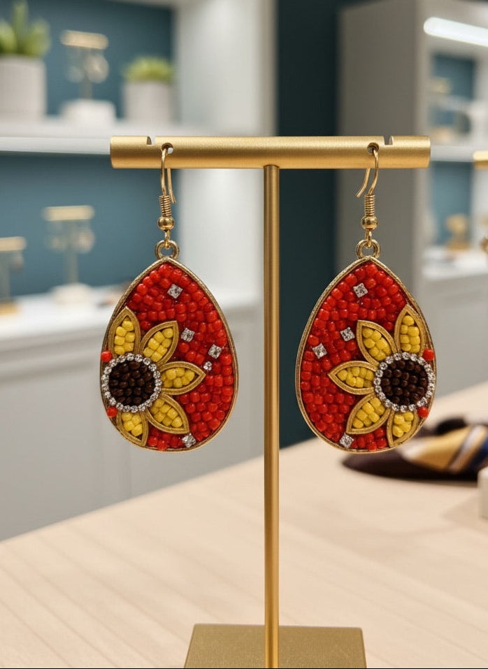 Decorative earrings with red and sunflowers on a gold stand 
