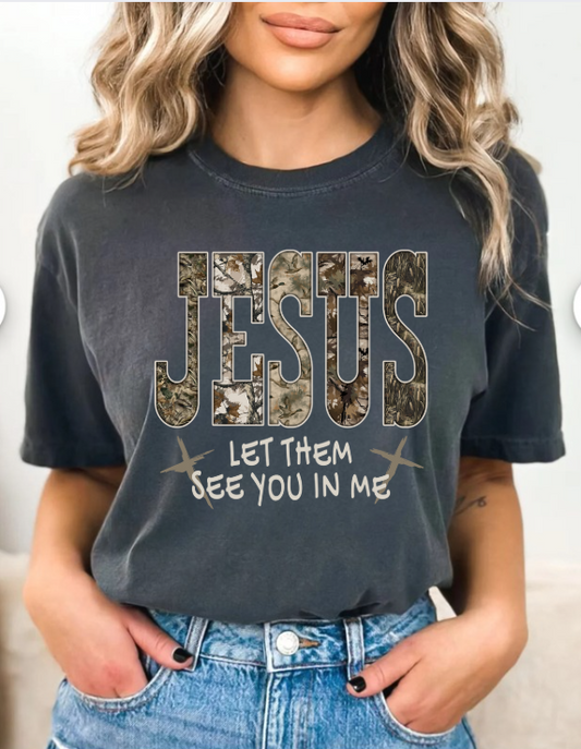 Person wearing a black t-shirt with 'Jesus Let Them See You In Me' text design.