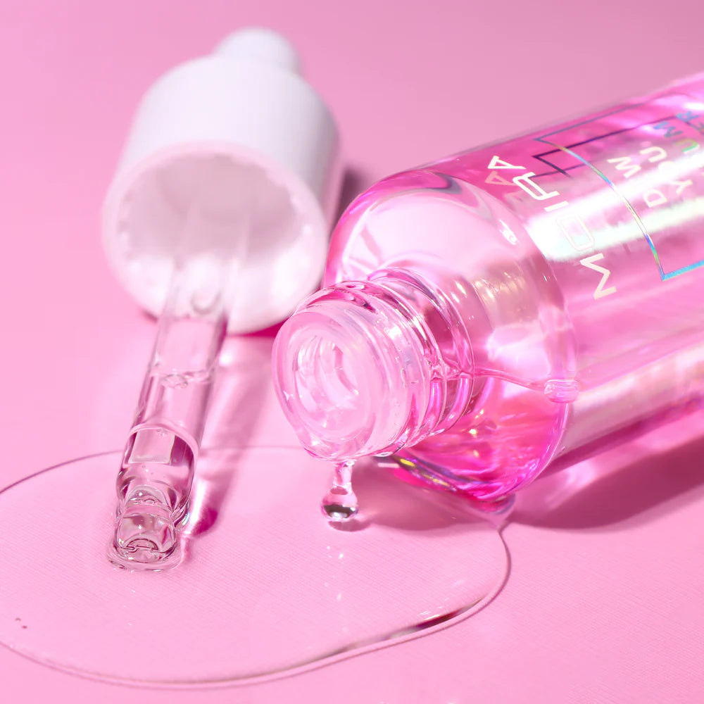 Pink skincare bottle with dropper on a pink background